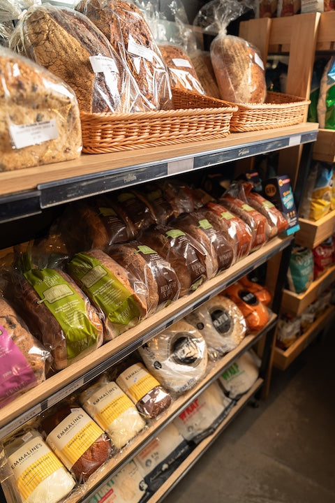 Shelf with various types of bread in a store setting