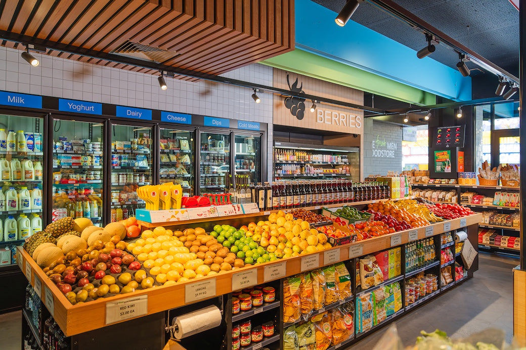 Supermarket interior with fresh produce and refrigerated sections.